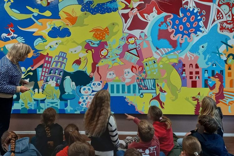 Beeldend kunstenaar Kitty Boon in gesprek met leerlingen van groep 7/8 uit Zuidlaren over een kunstwerk van de Toyisten.